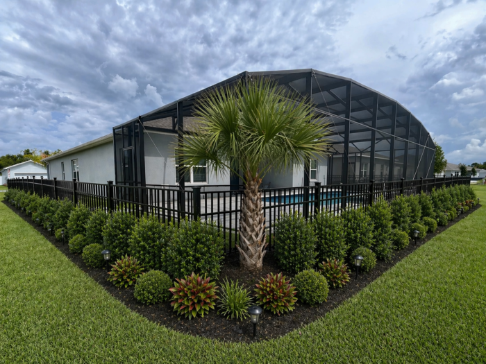 Screen enclosure with an aluminum picket fence around the yard